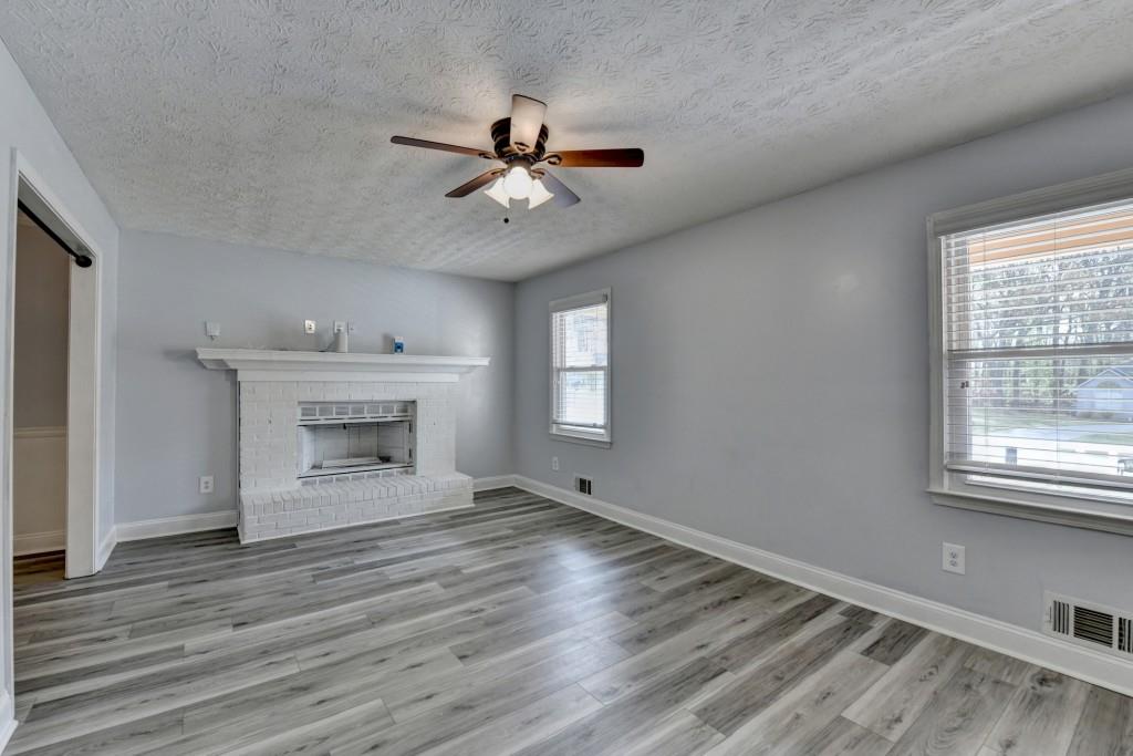 351 Cottonpatch Road Lawrenceville, GA 30046 - Photo 5 of 47 a view of an empty room with wooden floor and a window