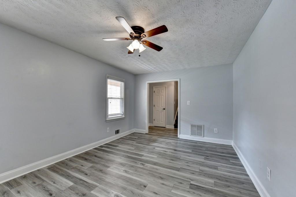351 Cottonpatch Road Lawrenceville, GA 30046 - Photo 6 of 47 a view of an empty room with window and wooden floor