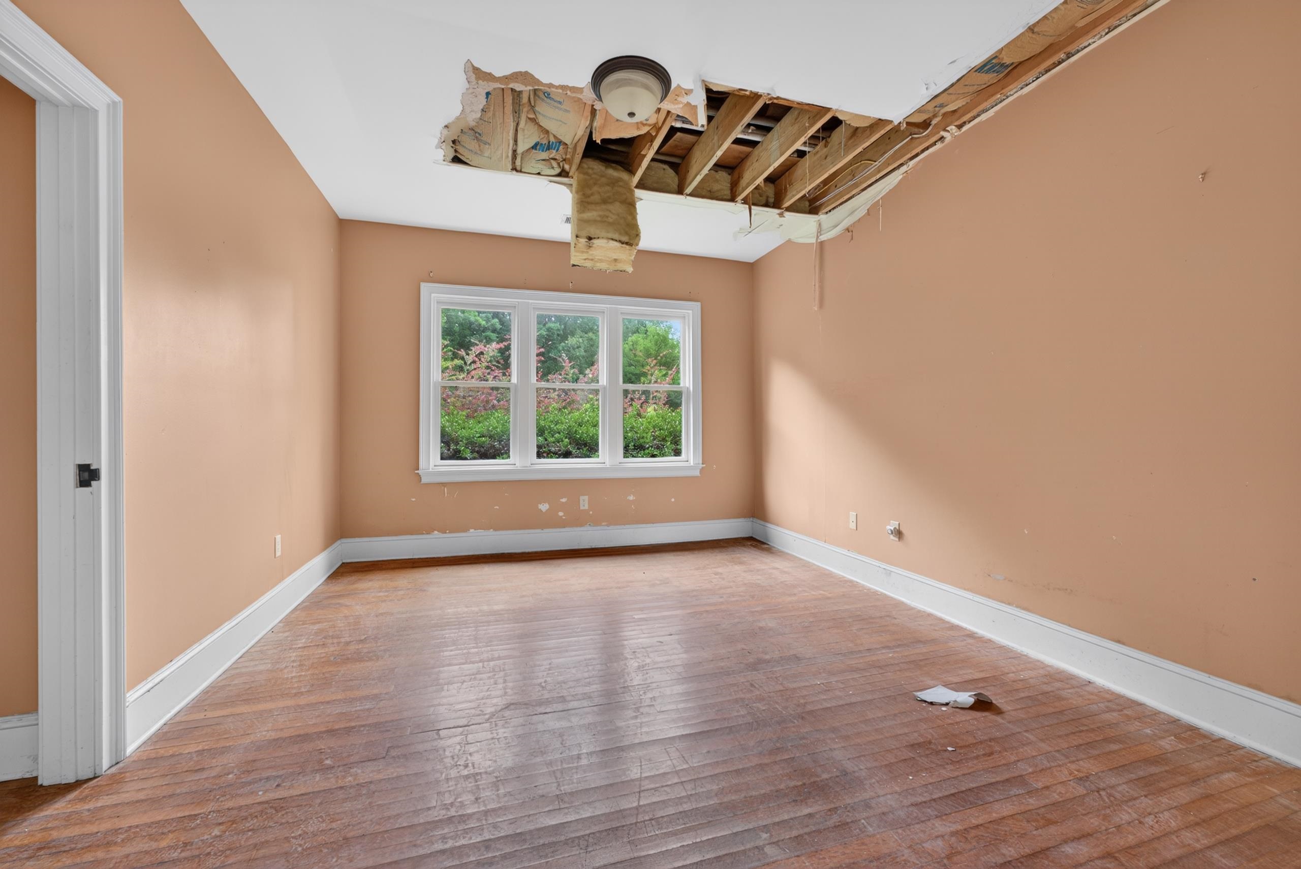530 West Raines Road Memphis, TN 38109 - Photo 25 of 38 Room featuring wood-finish flooring, a multi-pane window with white trim, and a partially exposed ceiling