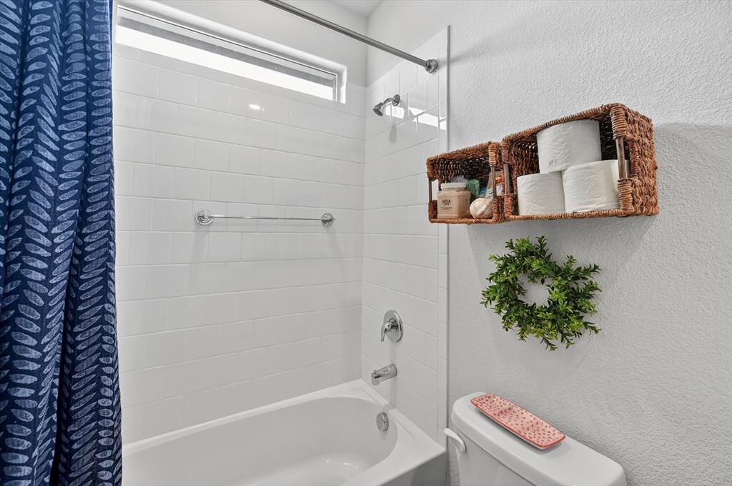 9604 Cherryville Road Fort Worth, TX 76108 - Photo 28 of 40 White subway tile shower surround with chrome fixtures and an overhead transom window