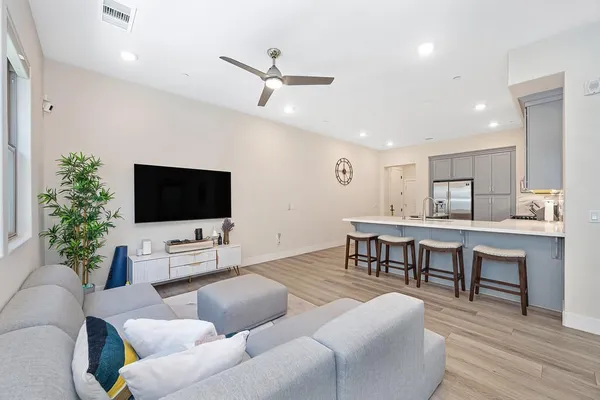 a living room with furniture a desk and chair with wooden floor