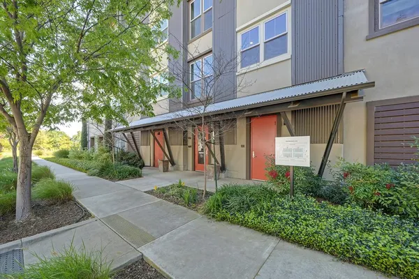 a front view of a house with a yard and trees