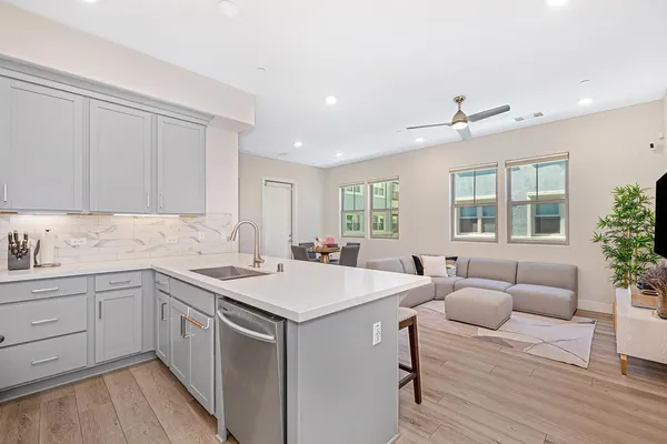 a kitchen with stainless steel appliances a table chairs refrigerator and cabinets