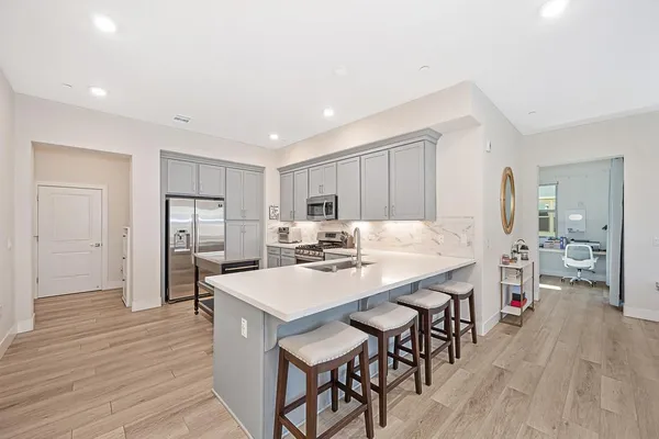 a dining hall with stainless steel appliances granite countertop a dining table and chairs