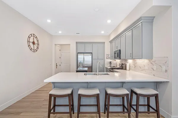 a kitchen with granite countertop white cabinets and stainless steel appliances