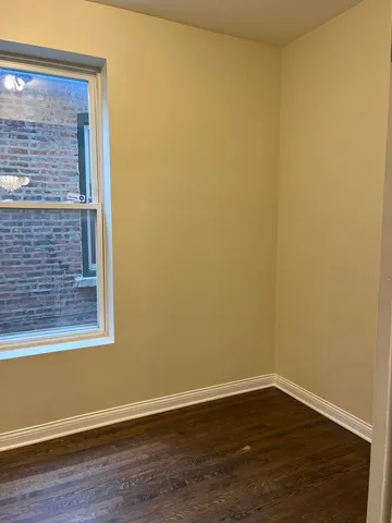 a view of a small space with wooden floor and a window