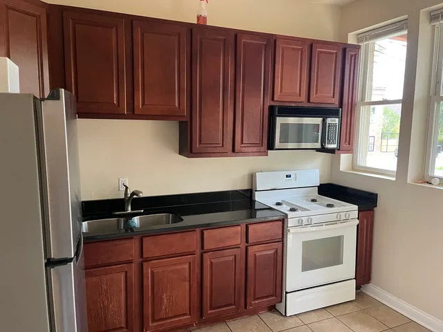 a kitchen with granite countertop wooden cabinets and black appliances