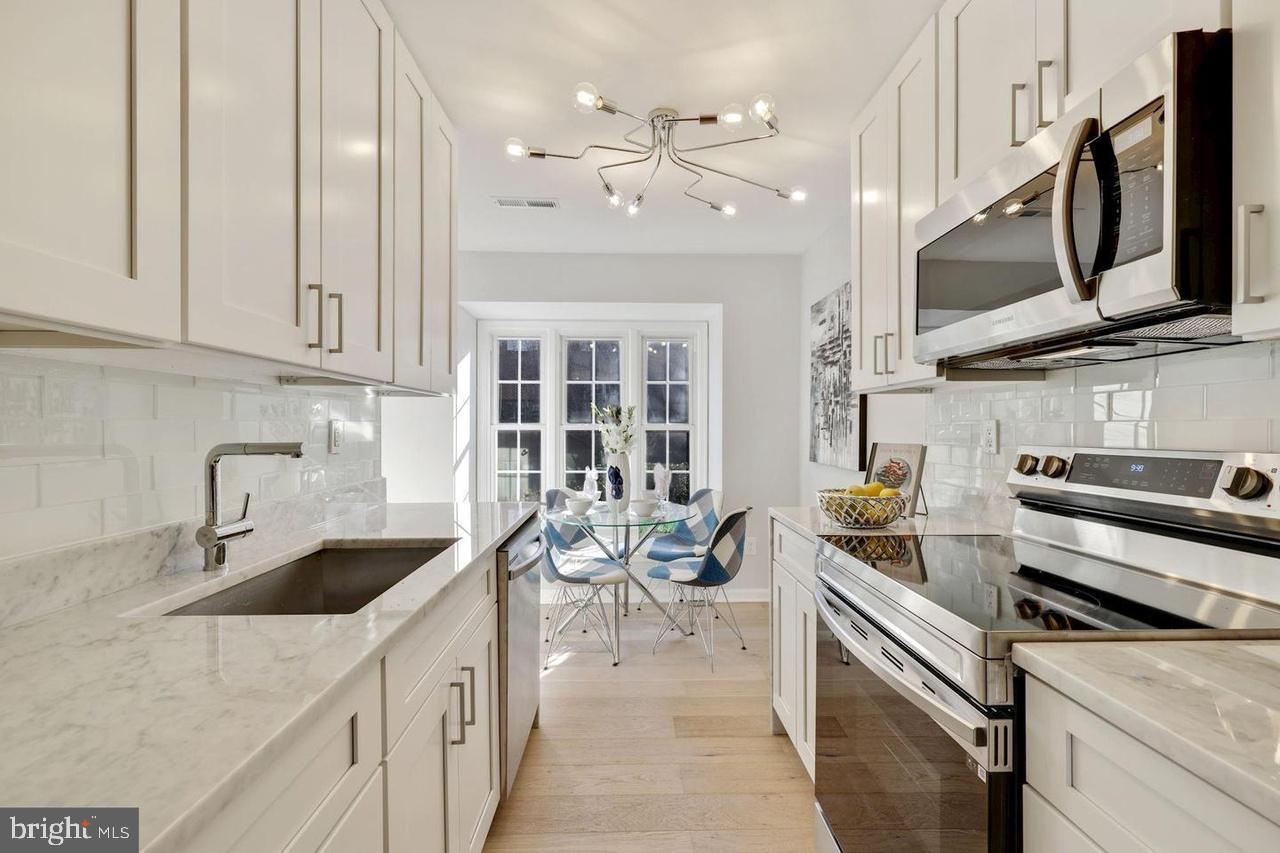 4940 Bradley Boulevard, Unit 247 Chevy Chase, MD 20815 - Photo 11 of 25 a kitchen with stainless steel appliances a sink a stove and cabinets
