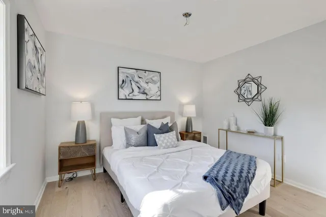 a bedroom with a bed and a lamp on dresser