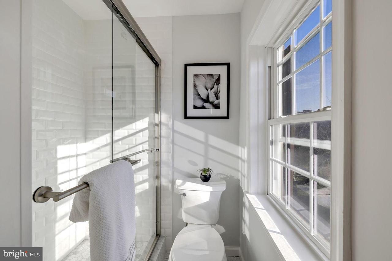 4940 Bradley Boulevard, Unit 247 Chevy Chase, MD 20815 - Photo 17 of 25 a bathroom with a toilet and a shower