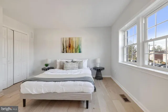 a bedroom with a bed a painting and a window