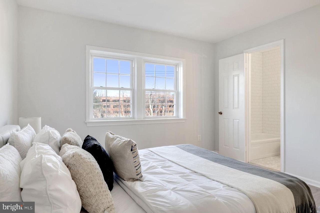 4940 Bradley Boulevard, Unit 247 Chevy Chase, MD 20815 - Photo 21 of 25 a bedroom with a bed and a window