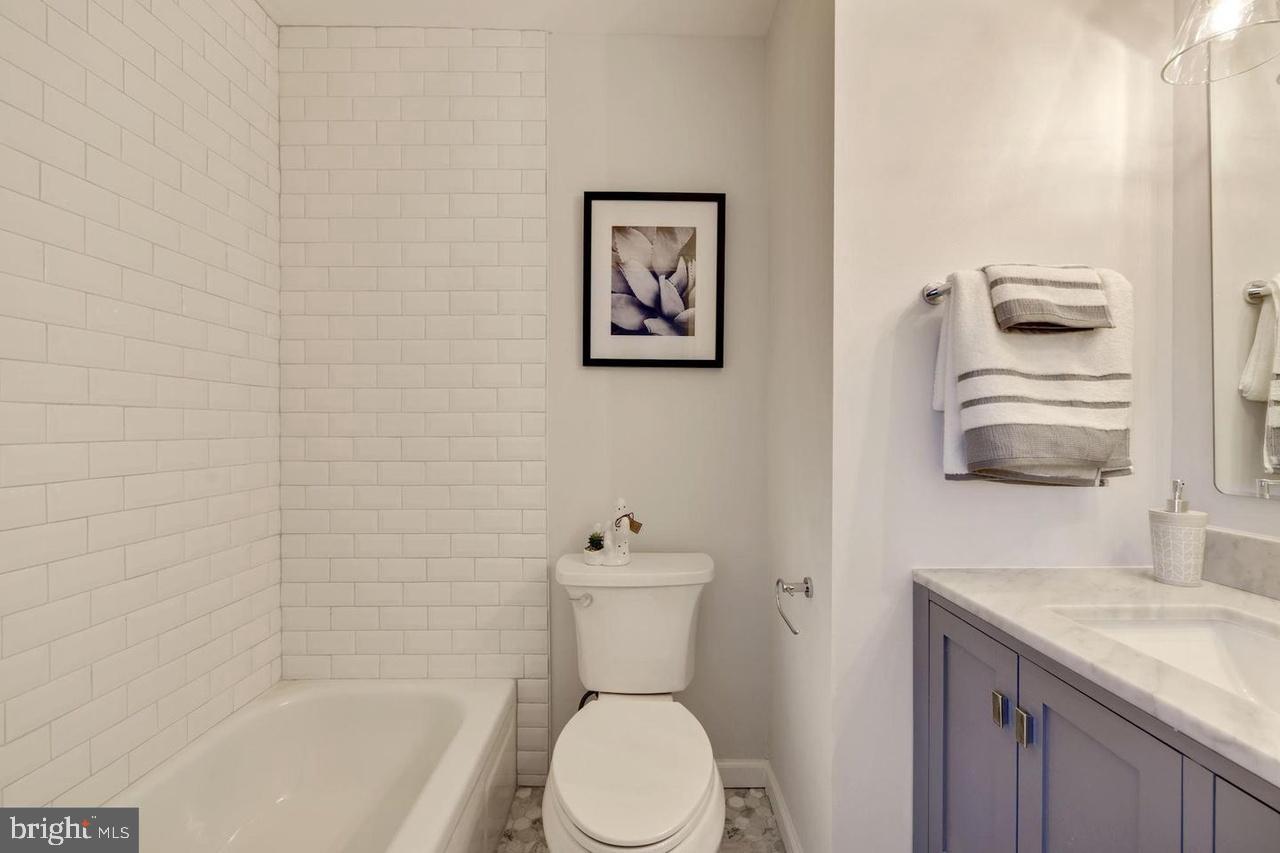 4940 Bradley Boulevard, Unit 247 Chevy Chase, MD 20815 - Photo 23 of 25 a bathroom with a toilet a sink and mirror
