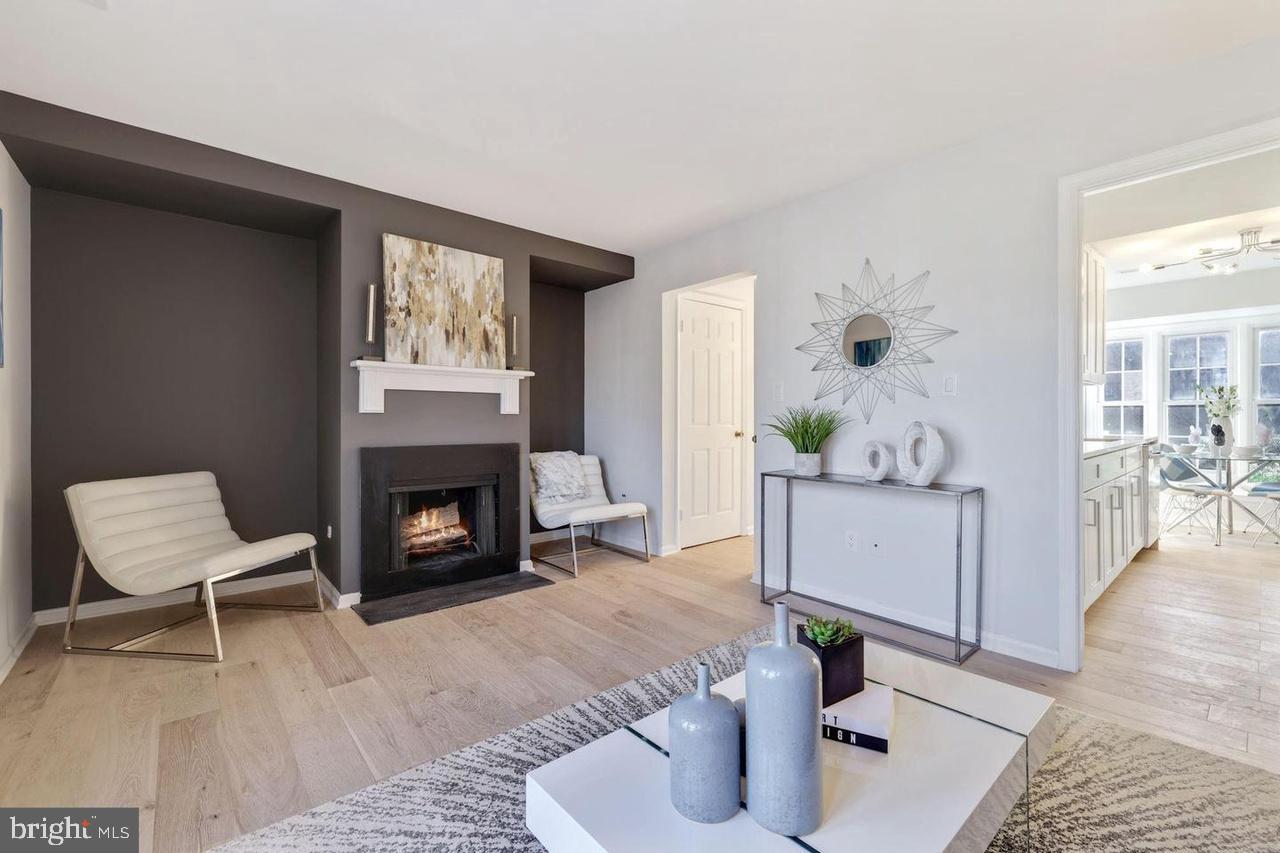 4940 Bradley Boulevard, Unit 247 Chevy Chase, MD 20815 - Photo 5 of 25 a living room with furniture and a fireplace