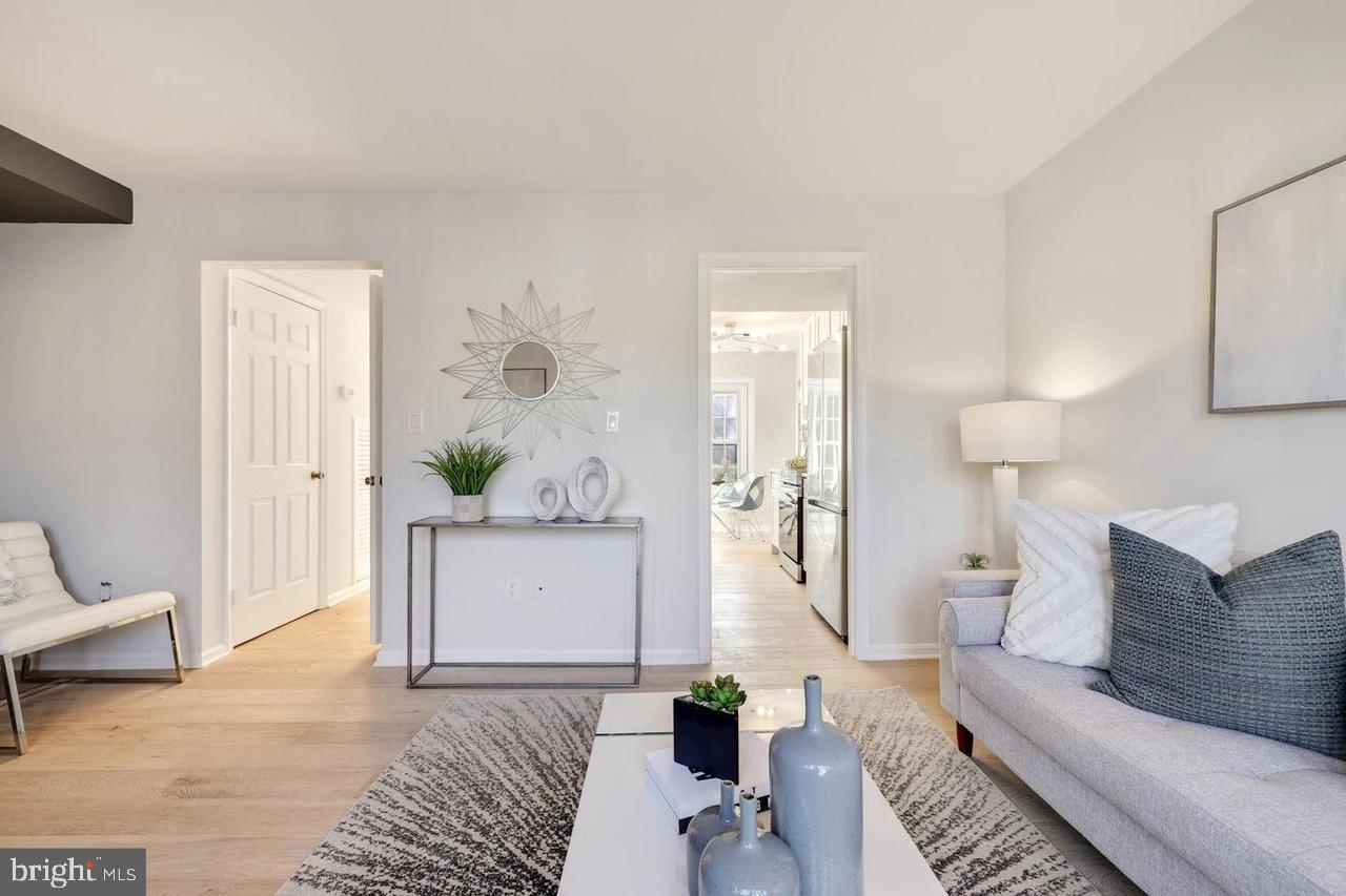 4940 Bradley Boulevard, Unit 247 Chevy Chase, MD 20815 - Photo 8 of 25 a living room with furniture and a potted plant