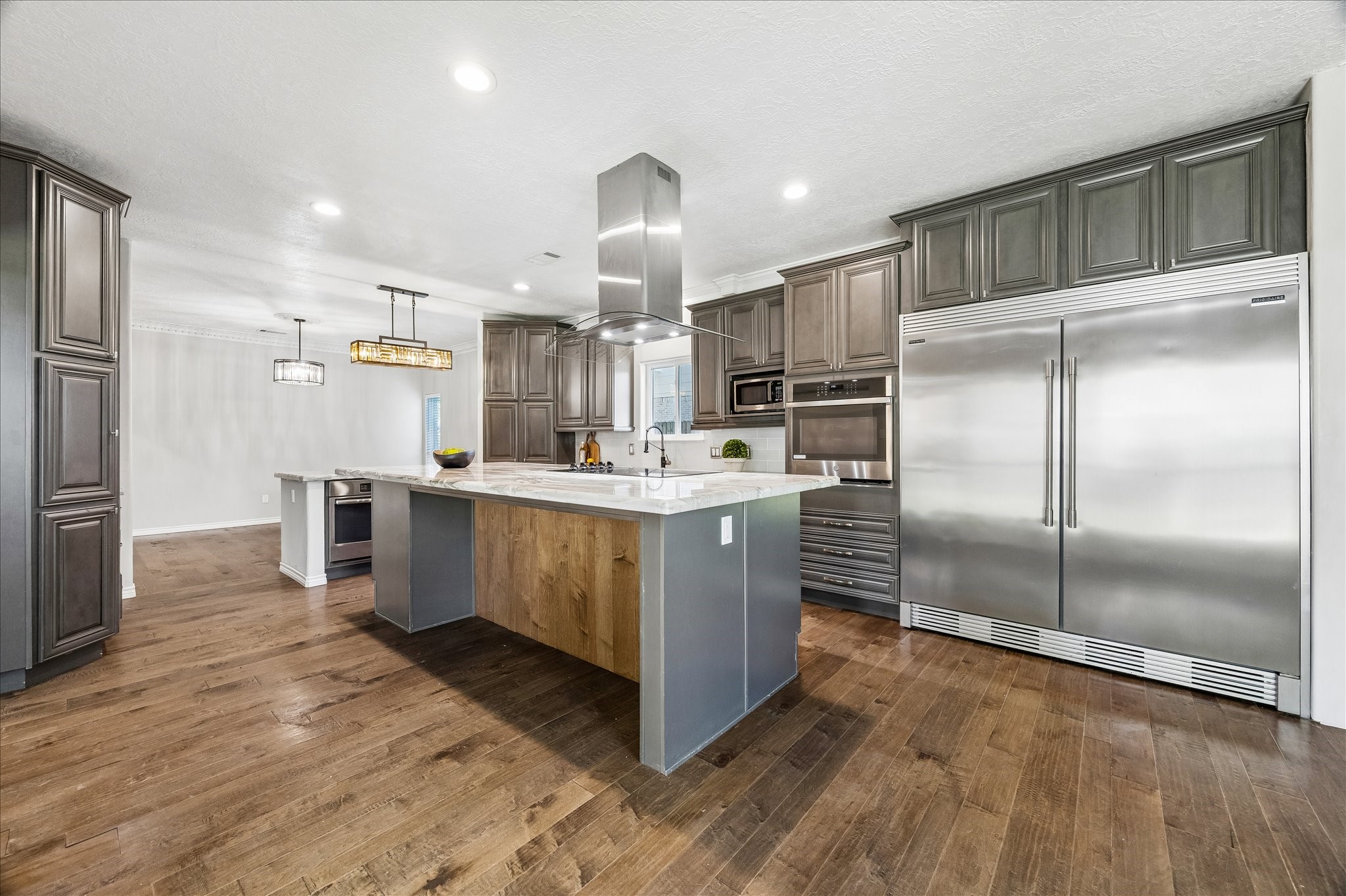 1030 Crossroads Drive Houston, TX 77079 - Photo 6 of 44 a kitchen with kitchen island a counter top space cabinets and stainless steel appliances