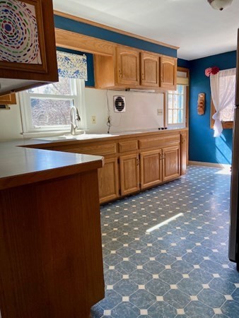 23 Adams Road Grafton, MA 01519 - Photo 18 of 32 a kitchen with a sink and a refrigerator