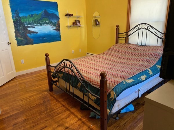 23 Adams Road Grafton, MA 01519 - Photo 22 of 32 a bedroom with a bed and wooden floor