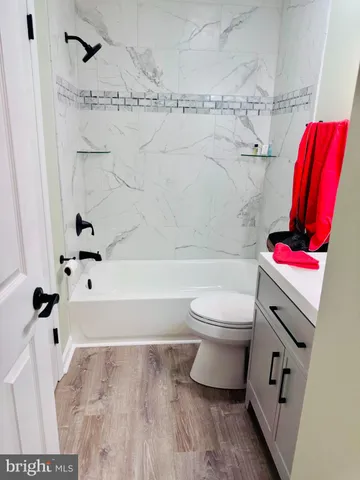 a bathroom with a bathtub shower sink vanity and toilet