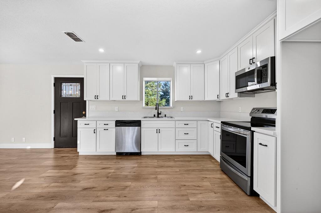3901 Luneman Road Placerville, CA 95667 - Photo 4 of 56 a kitchen with stainless steel appliances white cabinets a sink a stove a refrigerator and microwave