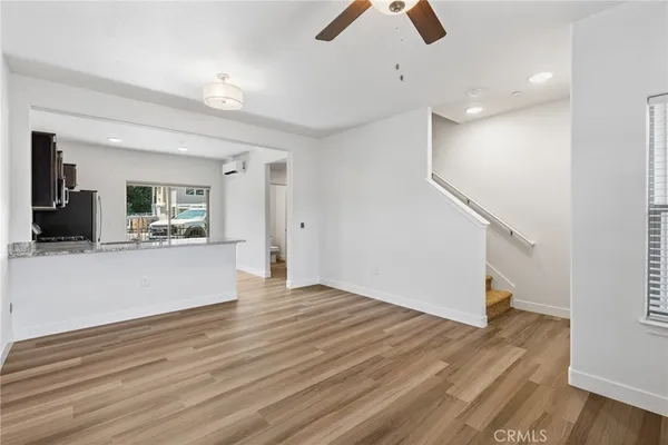 an empty room with wooden floor and a ceiling fan