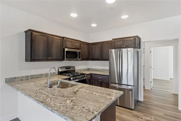 a kitchen with stainless steel appliances granite countertop a sink refrigerator and microwave