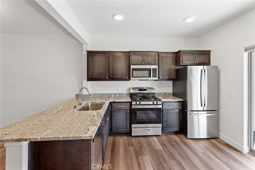 1991 Humboldt Road Chico, CA 95928 - Photo 7 of 12 a kitchen with granite countertop stainless steel appliances a refrigerator a stove top oven a sink and dishwasher