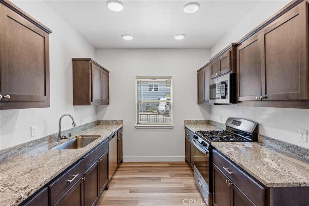 1991 Humboldt Road Chico, CA 95928 - Photo 8 of 12 a kitchen with granite countertop a sink a stove and cabinets