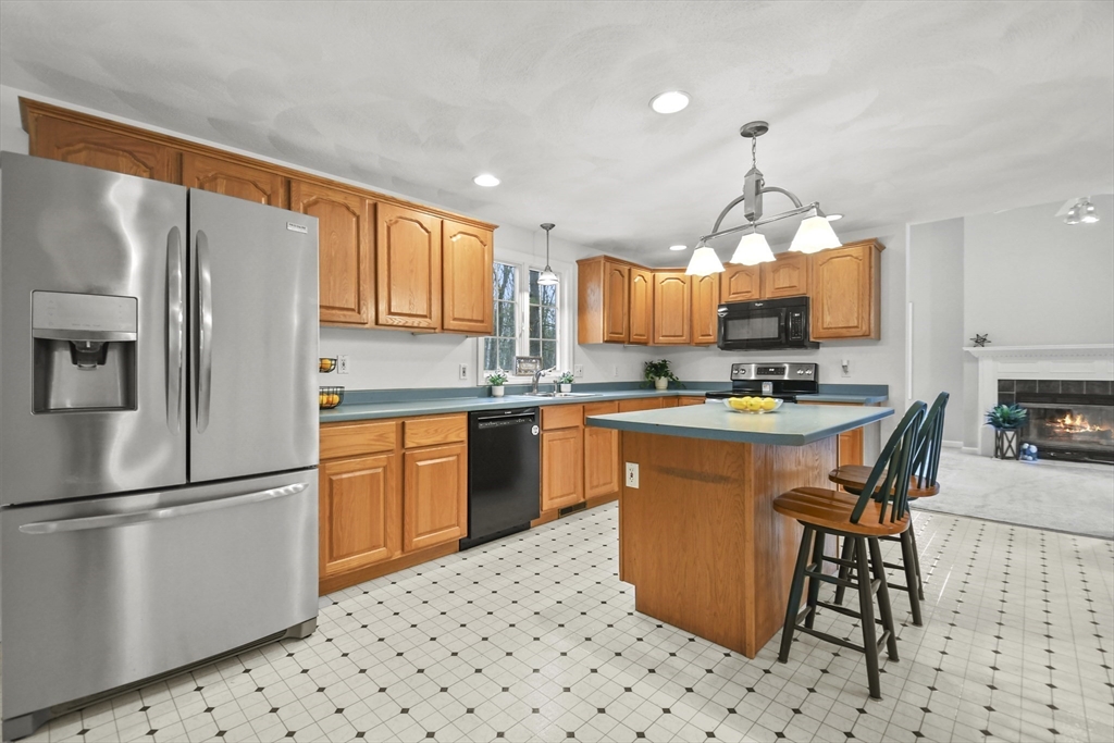47 Scribner Road Tyngsboro, MA 01879 - Photo 8 of 38 a kitchen with stainless steel appliances granite countertop a refrigerator a sink a stove a dining table and chairs