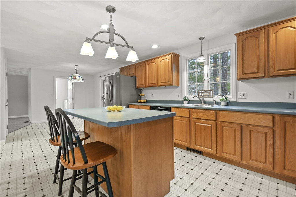 47 Scribner Road Tyngsboro, MA 01879 - Photo 9 of 38 a kitchen with stainless steel appliances a dining table chairs sink and cabinets