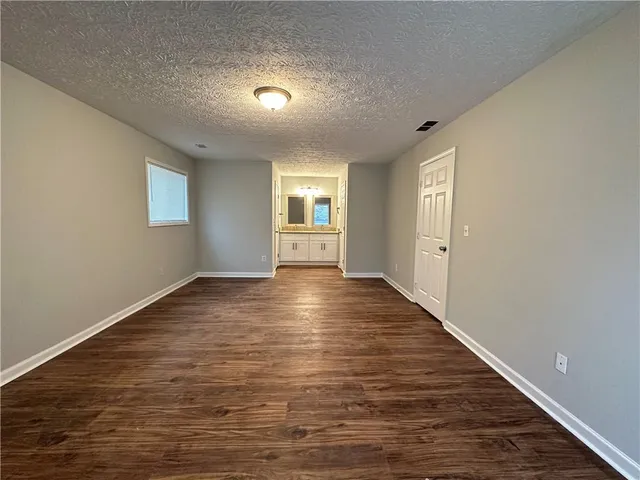 a view of empty room with wooden floor and window