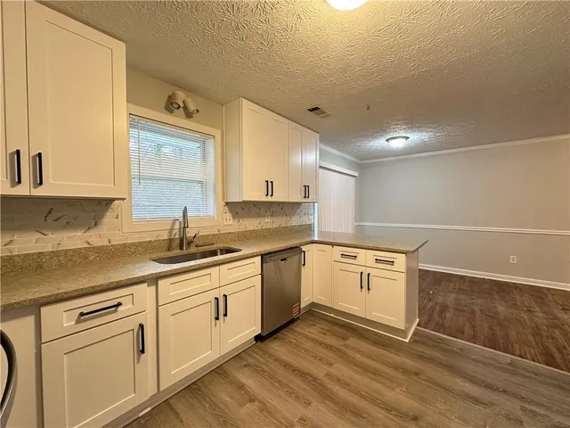 a kitchen with granite countertop white cabinets and white appliances