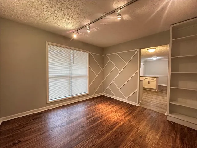 an empty room with wooden floor and door