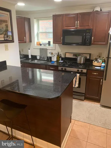 a kitchen with stainless steel appliances granite countertop a sink and a stove