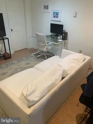 a living room with a bed and a flat screen tv