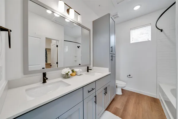 a bathroom with a double vanity sink and mirror with shower