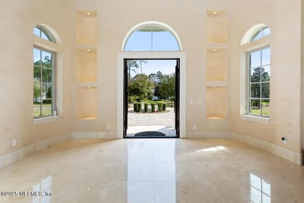 a bedroom with a large bed and a large window with outer view