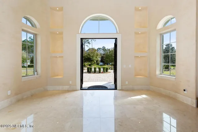 a bedroom with a large bed and a large window with outer view