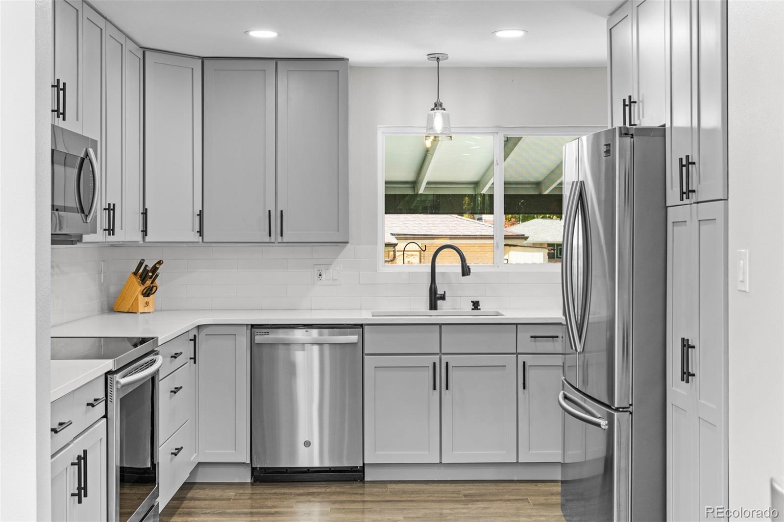 6000 Garrison Street Arvada, CO 80004 - Photo 13 of 50 a kitchen with stainless steel appliances granite countertop a refrigerator and a sink