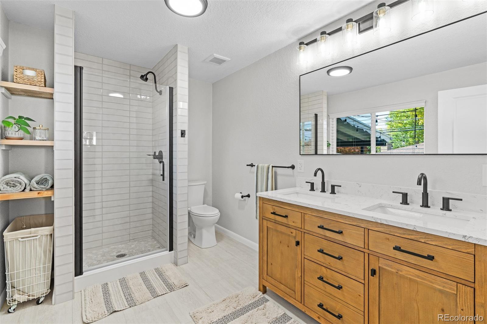 6000 Garrison Street Arvada, CO 80004 - Photo 19 of 50 a bathroom with a double vanity sink toilet and shower