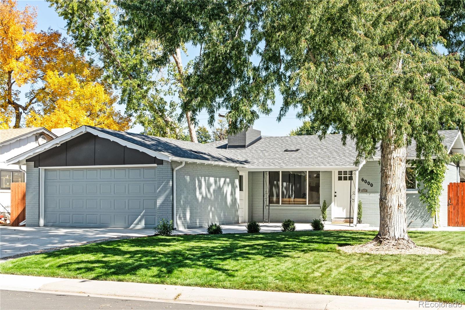 6000 Garrison Street Arvada, CO 80004 - Photo 2 of 50 a front view of a house with a garden