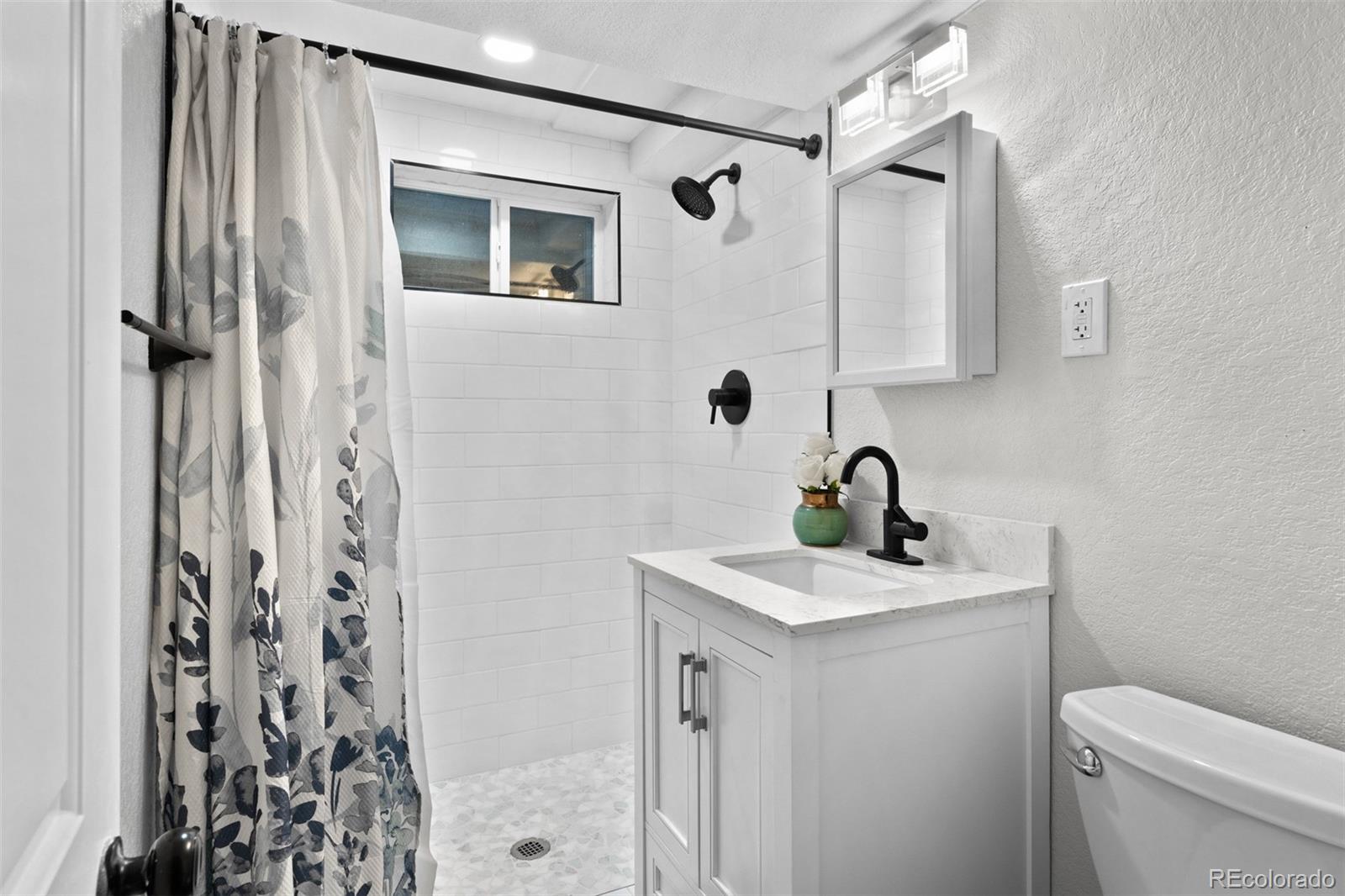 6000 Garrison Street Arvada, CO 80004 - Photo 29 of 50 a bathroom with a sink a toilet and shower