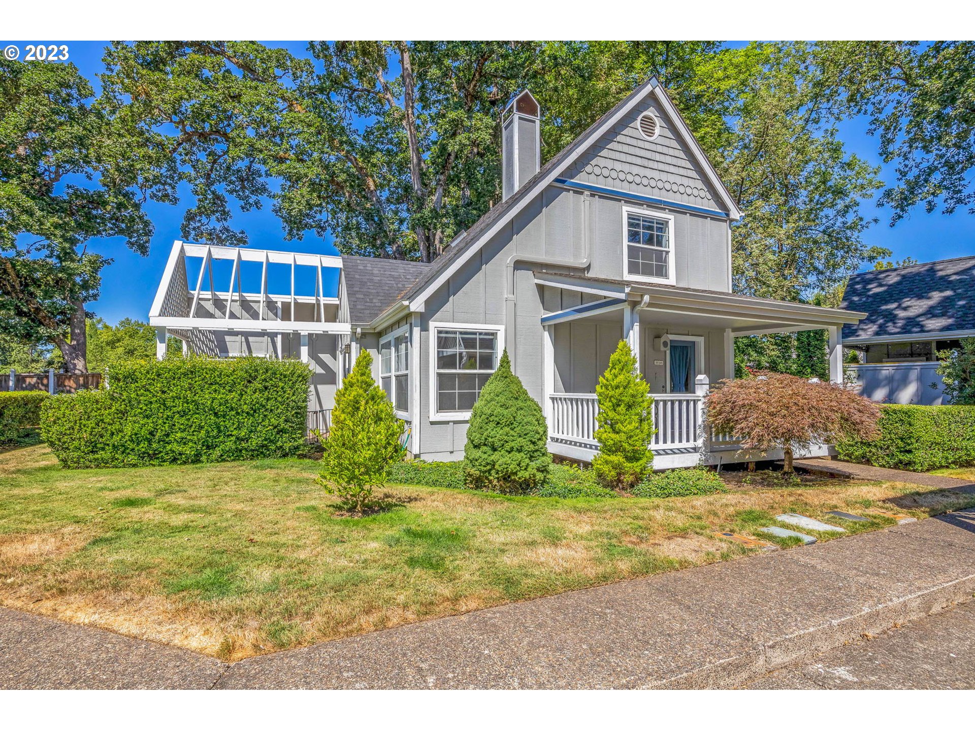 a view of a house with a yard and potted plants