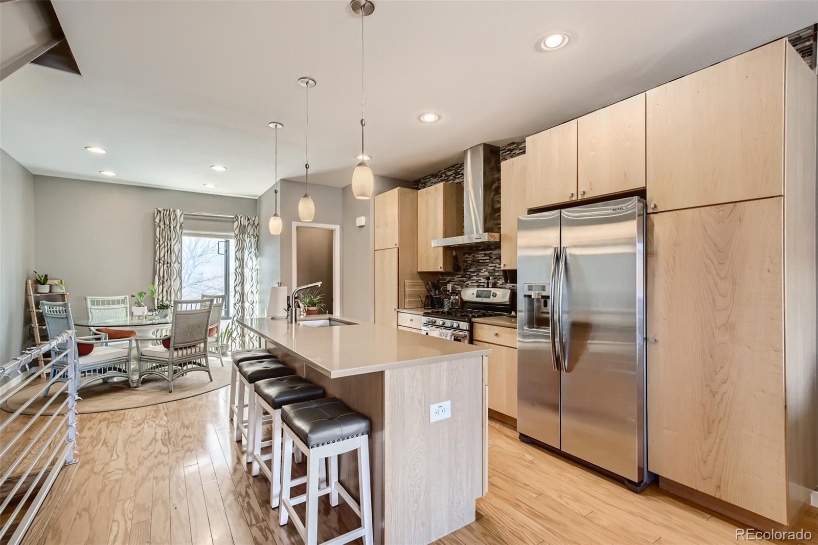 826 25th Street Denver, CO 80205 - Photo 9 of 23 a kitchen with stainless steel appliances a refrigerator a stove a sink dishwasher a oven with white cabinets and wooden floor