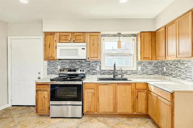 a kitchen with stainless steel appliances granite countertop a stove and a sink