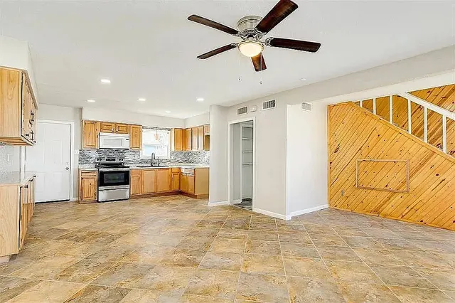 a kitchen with stainless steel appliances granite countertop a refrigerator and a sink
