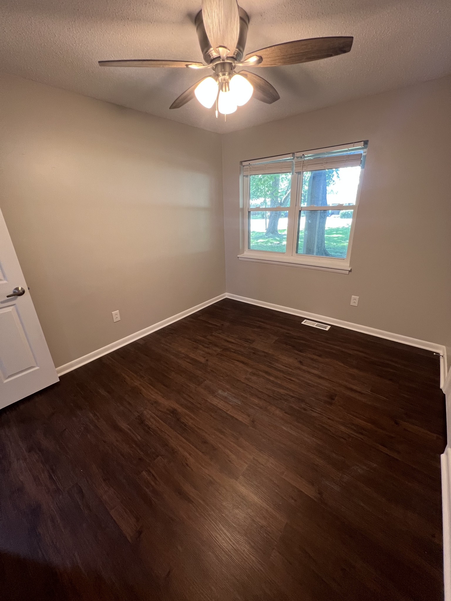 1846 Patrick Road Pulaski, TN 38478 - Photo 19 of 26 an empty room with wooden floor chandelier fan and windows