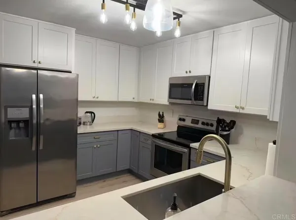 a kitchen with stainless steel appliances granite countertop a stove a sink and a refrigerator
