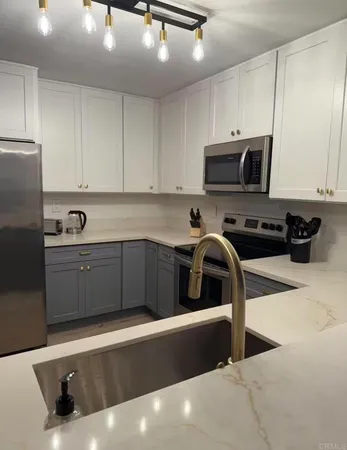 a kitchen with a sink a stove and cabinets