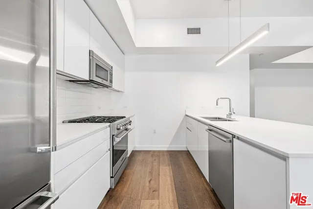 a kitchen with stainless steel appliances a sink stove and cabinets